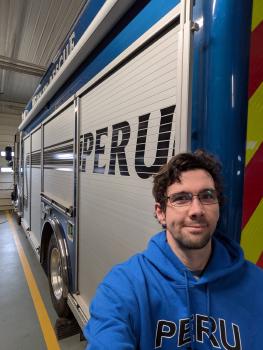 Eddie standing behind parked pump truck 276, Taz